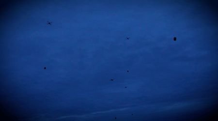 Drones carrying food packages fly over a location given as
