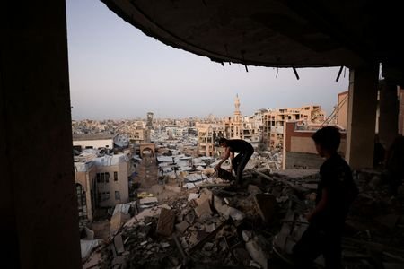 FILE PHOTO: Palestinian man works amid the rubble of a