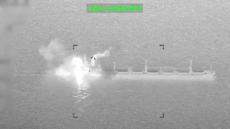 Smoke and fire rise from a commercial cargo vessel following