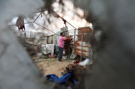 A Palestinian man inspects the site of an Israeli strike