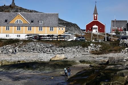 Two children play on the beach in the old harbour