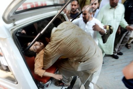 Rescue workers carry a boy injured after a school roof