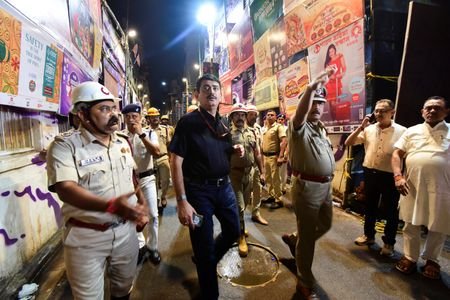 Police officers inspect the site of a stampede at a