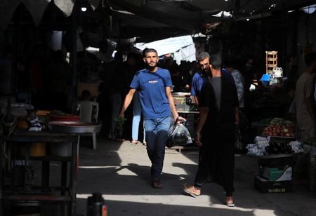 Palestinians walk through a street market in Gaza