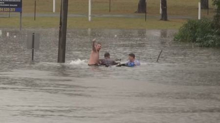 Australian Broadcasting Corporation reporter, Will Murray, and a bystander swim