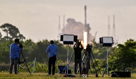 Photographers watch a SpaceX Falcon 9 rocket lift off from