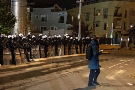 Riot police officers secure the area in front of the