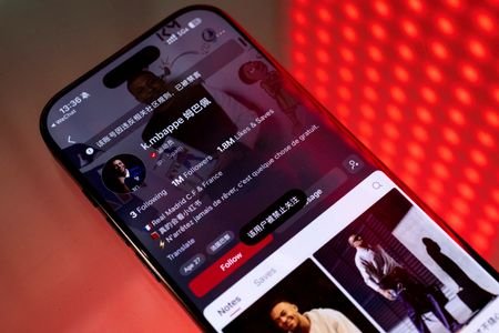 A smartphone displays the account of French soccer player Kylian