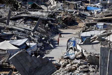 Palestinians live amid the rubble of buildings destroyed during the