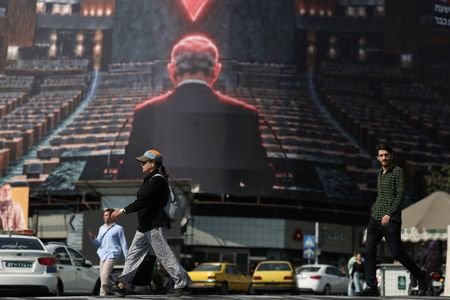 People walk past a billboard depicting Israeli Prime Minister Benjamin