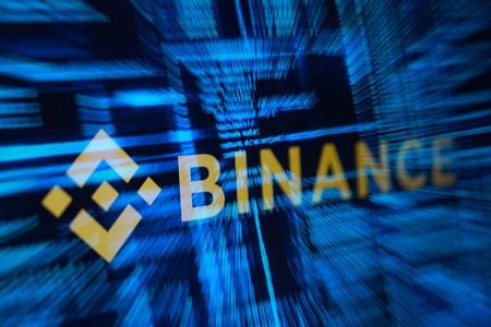 Illustration shows Binance logo and hacker code