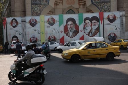 People drive next to a banner with a picture of
